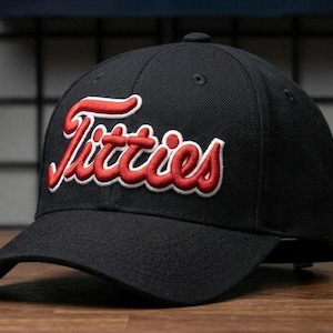 May include: A white ceramic mug with a black handle and the text "But First, Coffee" in a black, handwritten-style font. The mug is on a white surface.