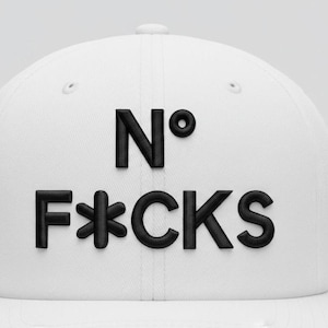 May include: White baseball cap with the phrase "N° F*CKS" embroidered in black. The cap has a curved brim and a structured crown. The text is in a bold, sans-serif font.