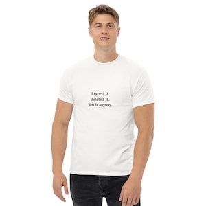 May include: White t-shirt with the text "i typed it. deleted it. felt it anyway." in a simple black font. The shirt is a classic crew neck style.