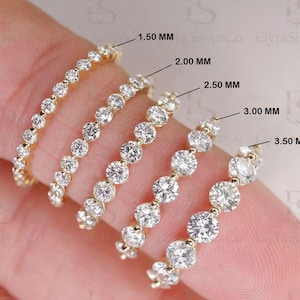 May include: A close-up of five gold rings, each set with clear gemstones of varying sizes, from 1.50 mm to 3.50 mm. The rings are displayed on a finger, highlighting the different designs and stone sizes in millimeters.
