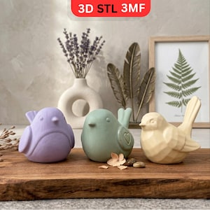 May include: A trio of cream-glazed ceramic mugs with a speckled finish. Each mug is adorned with a hand-painted floral pattern in blue, green, and yellow. The mugs have a simple, rounded form and a comfortable handle.