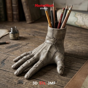 May include: A gray, hand-shaped pencil holder with visible stitching, holding several pencils of various colors. The base of the holder is a hand with detailed finger and knuckle features. The text "3D STL 3MF" is at the bottom.