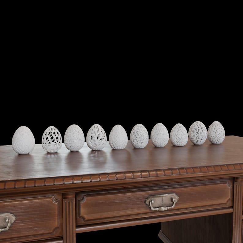 May include: A collection of nine white decorative eggs with various carved designs, displayed on a dark wooden table. The eggs have different patterns, including openwork and textured surfaces, against a black background.