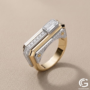 Angled view of a modern, geometric men's ring in two-tone yellow and white gold. The ring features an off-center emerald-cut diamond, a row of pave-set diamonds along the top, and industrial-style gold screw details on the side panels.