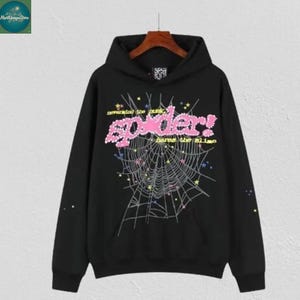 May include: Black hooded sweatshirt with a spider web design. The front features the word "spider!" in pink, with the phrases "neverend the dusk" and "bare the slime" above and below the spider web graphic.