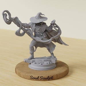 May include: A grey unpainted miniature figurine of a spellcaster wearing a wide-brimmed hat and a long coat, holding a swirling magical effect in one hand. The figure stands on a rocky base atop a circular wooden stand labeled Soul Sculpt.