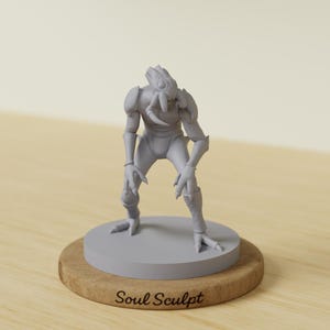 May include: A gray alien figurine with a detailed design, standing on a gray circular base atop a wooden stand. The figurine has a textured surface and the text "Soul Sculpt" is visible on the wooden base.