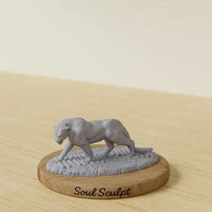 May include: A gray sculpture of a panther walking on a patch of grass, mounted on a round wooden base. The base has the text "Soul Sculpt" in a cursive font. The panther is detailed and realistic, with its head lowered and eyes focused.