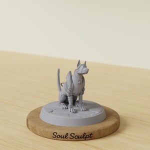Könnte beinhalten: Eine hellgraue Miniaturfigur eines sitzenden Hundes in mechanischer Rüstung, platziert auf einem runden Sockel mit steinartiger Textur. Der Sockel steht auf einer Holzscheibe mit dem eingravierten Text Soul Sculpt in schwarzer Schrift.