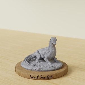 Pode incluir: Uma estatueta de dragão cinza-claro sem pintura, com escamas texturizadas e uma cauda longa, posicionada sobre uma base circular de madeira. A base apresenta o texto "Soul Sculpt" gravado em uma fonte cursiva escura na borda frontal.