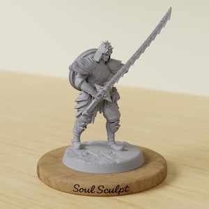 May include: A grey figurine of a warrior in armour, holding a large sword. The figure stands on a wooden base with the text "Soul Sculpt" in a script font. The warrior has a helmet and a shield on their back.