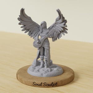 Puede incluir: Una figura miniatura gris de un personaje alado sobre una base texturizada, sosteniendo un instrumento de cuerda. La figura tiene alas emplumadas grandes y detalladas, montada sobre una base de madera redonda con el texto Soul Sculpt.