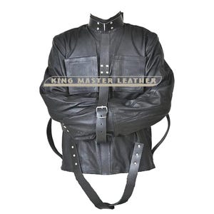 May include: Black leather straight jacket with a high collar, two front pockets, and multiple straps with buckles. The jacket has the text "KING MASTER LEATHER" across the chest.