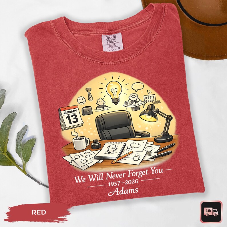 May include: Red t-shirt with a graphic design featuring a desk scene with a calendar, coffee cup, and a lightbulb. The text "We Will Never Forget You" and the name "Adams" are also printed on the shirt.