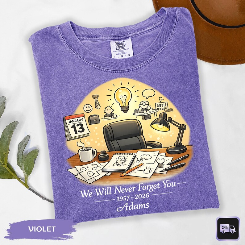 May include: Violet Comfort Colors t-shirt with a graphic of an office scene, including a desk, lamp, and calendar showing January 13. Text reads "We Will Never Forget You" and "Adams".