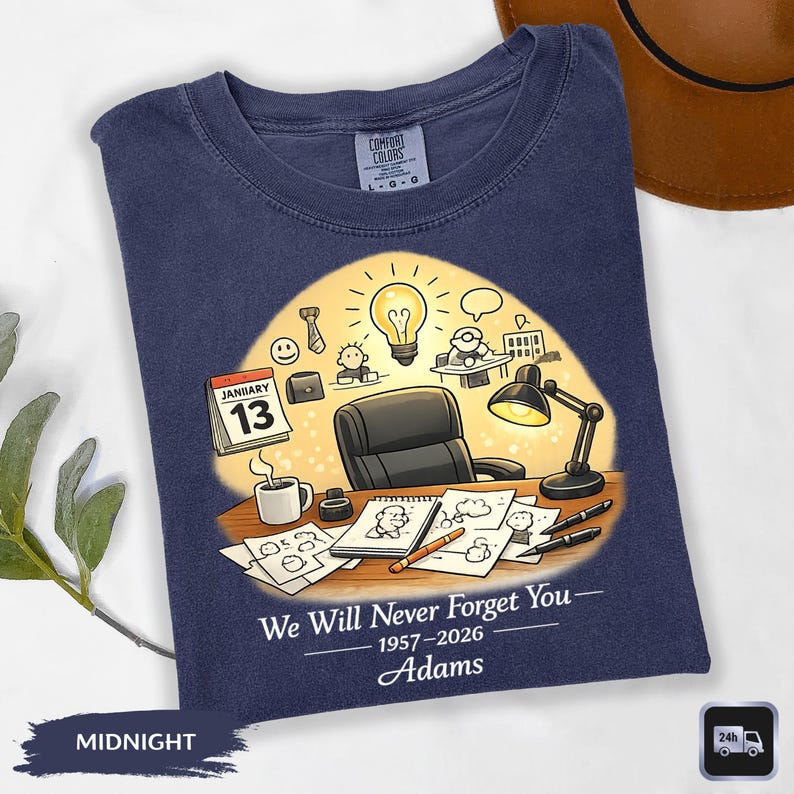 May include: Midnight blue Comfort Colors t-shirt with a graphic design. The design features an office scene with a desk, lamp, and calendar. Text reads "We Will Never Forget You - 1957-2026 Adams".