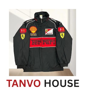 Könnte beinhalten: Schwarze Ferrari-Rennjacke mit roten und weißen Akzenten. Mit Ferrari-Logo, F-1-Patches und Sponsorenlogos. Die Jacke hat einen durchgehenden Reißverschluss und einen Stehkragen. Der Schriftzug "Ferrari" ist auf der Brust zu sehen.