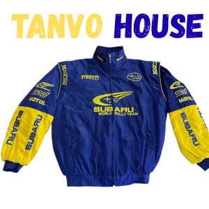 Może przedstawiać: Niebiesko-żółta kurtka Subaru World Rally Team z napisem "TANVO HOUSE". Kurtka ma pełny zamek błyskawiczny, stójkę i logo sponsorów. Rękawy są żółte z nadrukiem "SUBARU".