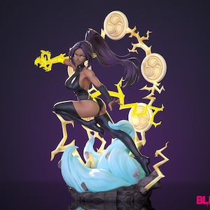 May include: A dynamic figurine of a woman in a black outfit, poised in a fighting stance. The figure has dark hair and is surrounded by stylized lightning bolts and circular emblems. The base features light blue and white accents, with the word "BLEACH" in pink.