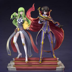 May include: Two anime character figurines. One figure has green hair, a dark dress, and is holding a yellow plush. The other figure has black hair, a purple suit, and a red cape. Both figures are standing on a red carpeted platform.