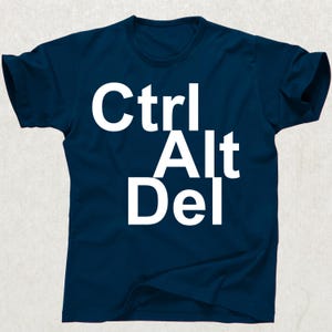 Puede incluir: Camiseta azul marino con el texto blanco "Ctrl Alt Del" apilado. La camiseta tiene mangas cortas y cuello redondo.