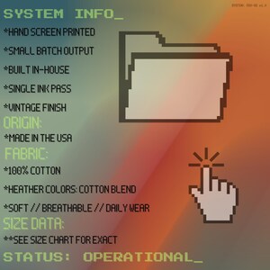 May include: A graphic with text and pixelated icons on a gradient background. Text includes "SYSTEM INFO", "HAND SCREEN PRINTED", "MADE IN THE USA", and "100% COTTON". A pixelated folder and a clicking hand icon are also present.