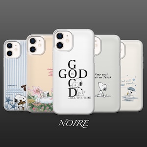 May include: A collection of phone cases featuring Snoopy designs and religious quotes. The cases display various images, including Snoopy with a cross, Snoopy with flowers, and Snoopy with the text "GOD IS GOOD". The cases are white and have a glossy finish.