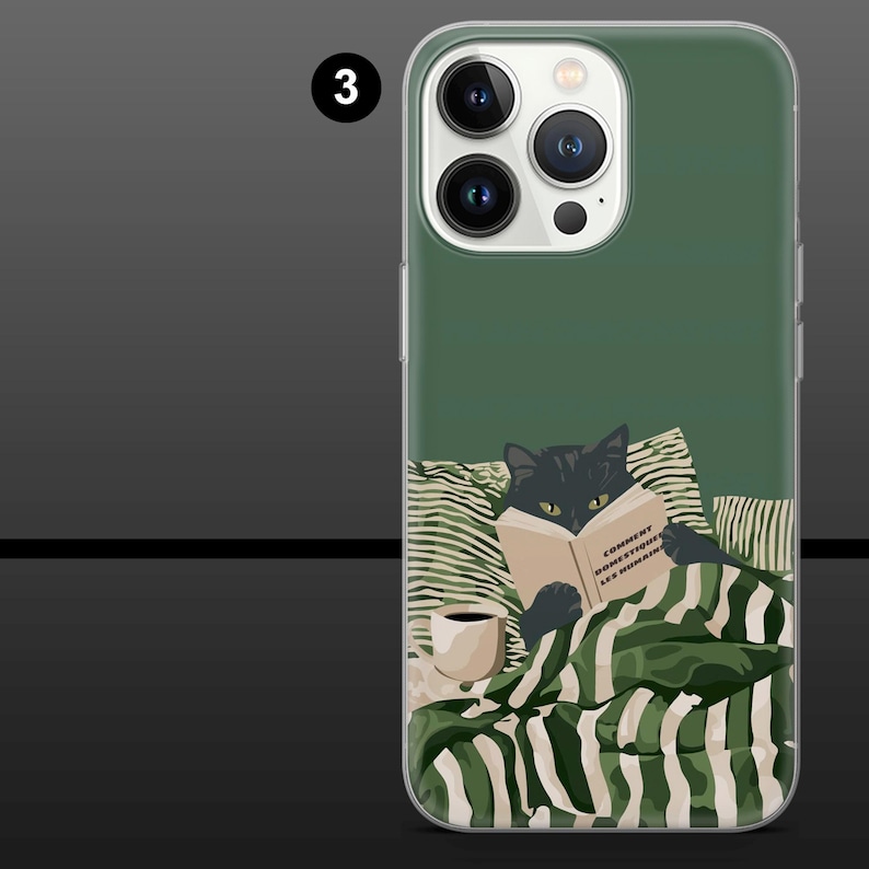 May include: A phone case with a green background featuring a black cat reading a book with the text "COMMENT DOMESTIQUER LES HUMAINS". The cat is under a green and white striped blanket, with a coffee cup on the side.