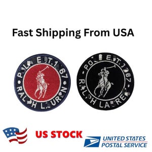 May include: Two circular patches with the text "POLO RALPH LAUREN EST. 1967". One patch has a red center with a white polo player, the other has a black center with a white polo player. The patches are surrounded by a navy blue border.