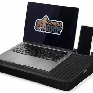 Op de afbeelding: Zwart laptopbureau met een koolstofvezelpatroon, met een laptop en een smartphone. Het laptopscherm toont het "Gorilla Grip" logo. Extra kleuropties worden links getoond.
