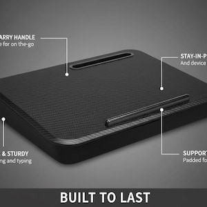 Op de afbeelding: Zwart laptopbureau met een getextureerd oppervlak, met een gemakkelijk te dragen handvat en een stay-in-place richel. Het bureau is ontworpen met ondersteunend schuim voor comfort en is gebouwd om lang mee te gaan. De tekst "BUILT TO LAST" staat onderaan.