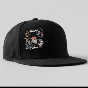 May include: Black snapback hat featuring a graphic of Michael Jackson. The graphic includes images of Jackson and his name. The hat has a flat brim and a structured crown, suitable for casual wear.