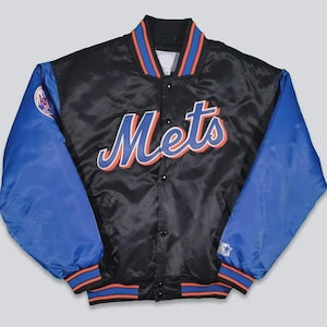 May include: Black satin jacket with blue sleeves and the word "Mets" in script across the chest. The jacket has orange and blue trim on the collar, cuffs, and waist. A team logo is on the left sleeve.