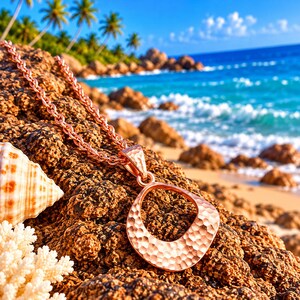 May include: A rose gold-toned necklace featuring a pendant with an irregular, open-centre shape and a hammered, textured surface. The pendant is attached to a matching rose gold-toned chain with a classic link design.