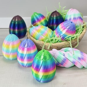 May include: A collection of colorful, decorative Easter eggs in a woven basket with green paper grass. The eggs are in various colors, including blue, green, purple, and yellow, with a striped pattern. Some eggs are open, revealing the interior.