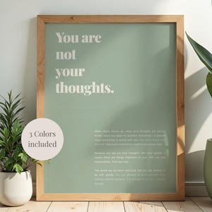 Könnte beinhalten: Ein gerahmter Druck mit dem Text "You are not your thoughts" in heller Schrift auf einem salbeigrünen Hintergrund. Der Holzrahmen umgibt den Druck. Ein kleiner Kreis links sagt "3 Farben enthalten."