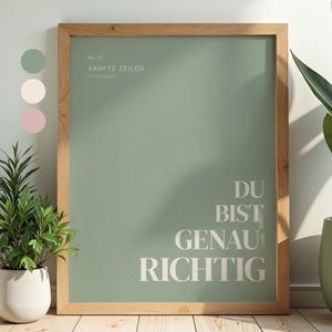 Könnte beinhalten: Ein gerahmtes Wandbild mit einem salbeigrünen Hintergrund und weißem Text, der No. 01 SANFTE ZEILEN for full minds und DU BIST GENAU RICHTIG lautet. Der Druck befindet sich in einem hellen Holzrahmen mit einer sichtbaren Maserung.