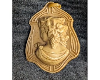 Pingente antigo/vintage em celuloide bege com camafeu representando o perfil de uma mulher.