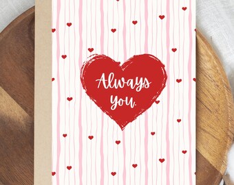 May include: A greeting card with a red heart that says "Always you" on a white background with pink vertical stripes and small red hearts. The card is inside a tan envelope.