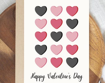 May include: Valentine's Day greeting card with a beige envelope. The card features a grid of sixteen hearts in black, pink, and red. The words "Happy Valentine's Day" are written in a cursive font at the bottom.