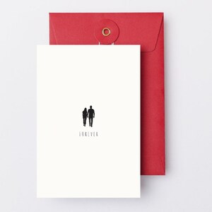 May include: A white greeting card with a black silhouette of a couple holding hands, with the word "FOREVER" below. The card is paired with a red envelope with a circular closure.