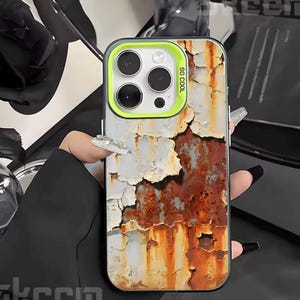 Könnte beinhalten: Eine Handyhülle mit einem Design aus verwittertem Metall. Die Hülle hat ein verwittertes, rostiges Aussehen mit abblätternder Farbe in Weiß-, Braun- und Orangetönen. Der Kamerabereich hat einen limettengrünen Rand mit dem Text "SO COOL".