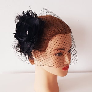 May include: A black bridal veil with a black flower and feather embellishment.