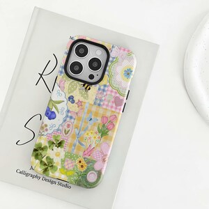 May include: A patterned phone case with a patchwork design. The case features floral, butterfly, and gingham patterns in yellow, pink, and blue. The text "Calligraphy Design Studio" is visible at the bottom of the case.