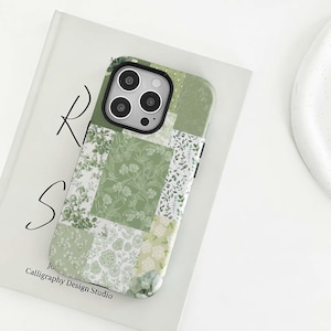 Pode incluir: Uma capa de telefone com patchwork floral verde e branco. A capa apresenta uma variedade de padrões florais verdes em um design de patchwork. A capa do telefone está em um livro branco com o texto "Calligraphy Design Studio".