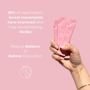 Puede incluir: Una mano sosteniendo tres sobres rosas de Re:Bio! contra un fondo rosa. El texto de la imagen indica que el 85% de los encuestados mejoraron sus movimientos intestinales despu&eacute;s de tomar Re:Bio!. El texto tambi&eacute;n dice Restaurar el equilibrio y Aliviar las molestias.