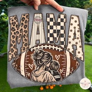 Puede incluir: Una camiseta gris con la palabra MAMA en letras grandes con patrones variados que incluyen estampado de leopardo, rayas verticales, cuadros en blanco y negro y lunares. Debajo hay un balón de fútbol americano marrón con una madre y un niño.