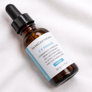 May include: A brown glass dropper bottle of SkinCeuticals C E Ferulic serum with a black dropper cap. The white label features blue text detailing the ingredients including 15% L-ascorbic acid, 1% alpha tocopherol, and 0.5% ferulic acid, totaling 30 ml / 1 fl oz.