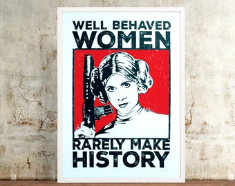 May include: A red and white poster with a black and white image of Princess Leia holding a blaster. The text on the poster reads "Well Behaved Women Rarely Make History."