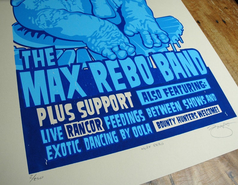 May include: A blue and white poster for "The Max Rebo Band" with the text "Plus Support" and "Also Featuring: Live Rancor Feedings Between Shows and Exotic Dancing by Oola". The poster also includes the text "Bounty Hunters Welcome!"